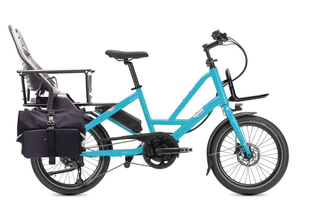 Blue compact cargo eBike with a rear child seat and a black pannier bag attached to the rack.